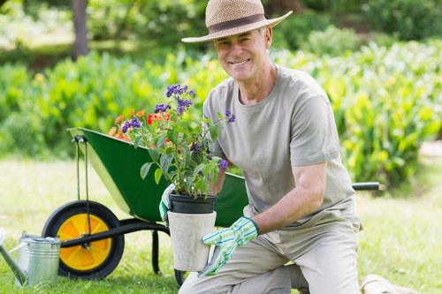 Technician performing safe landscaping work with protective equipment